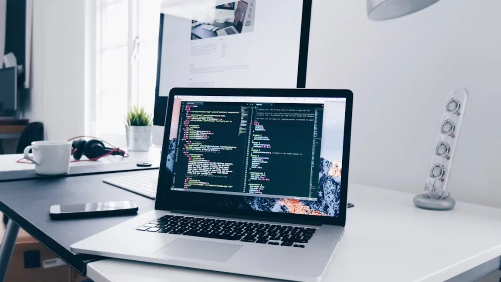 Developer workspace with laptop showing code — representing AI strategy and technology leadership