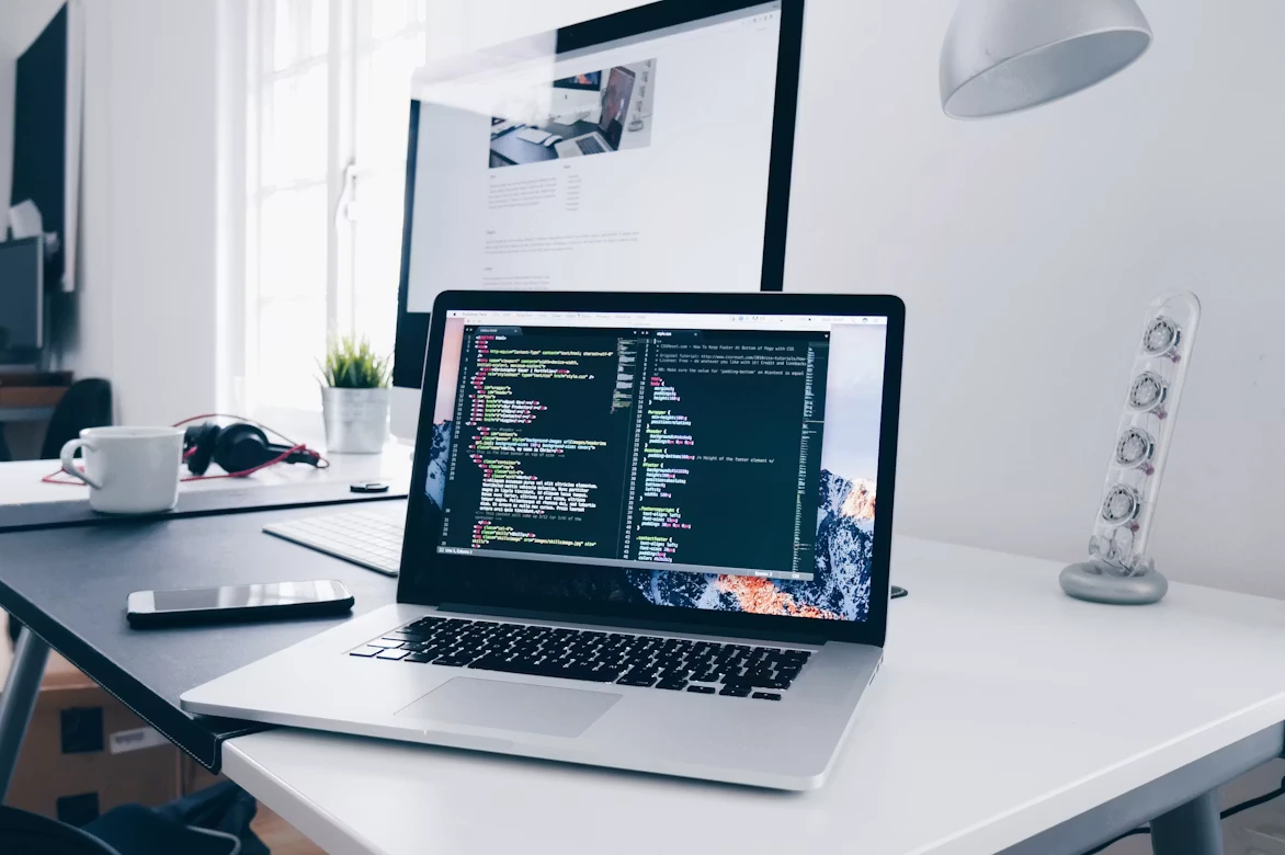Developer workspace with laptop showing code — representing AI strategy and technology leadership